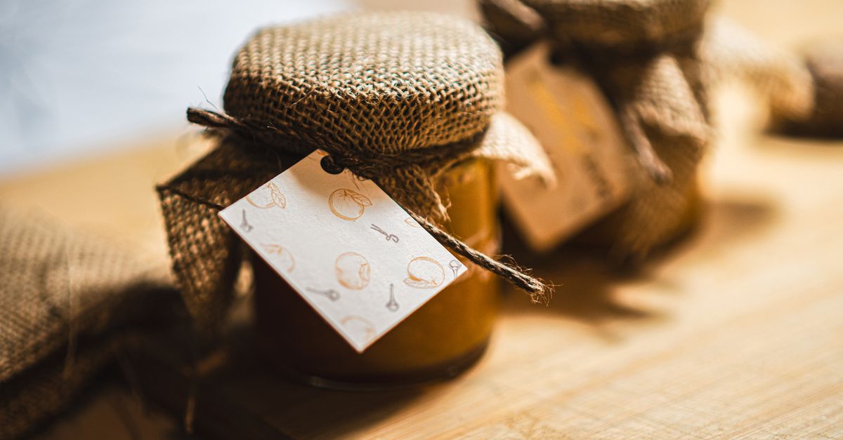 Kitchen table with jars, labels, and preserving utensils